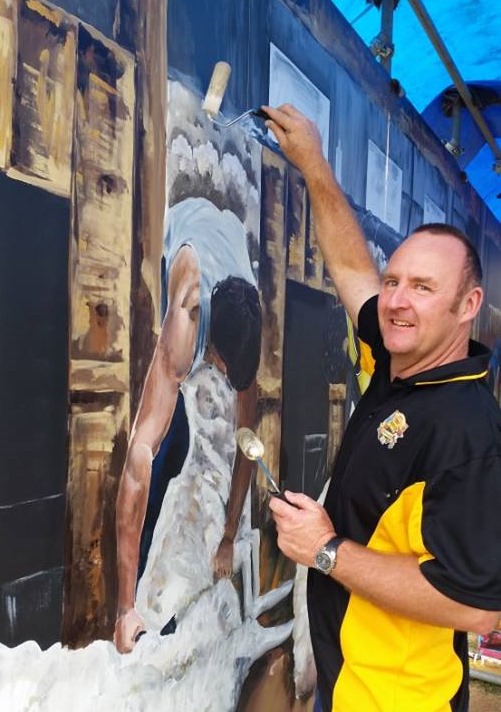 Peter Fishlock from Freestyle Signs painting murals at Eugowra, NSW